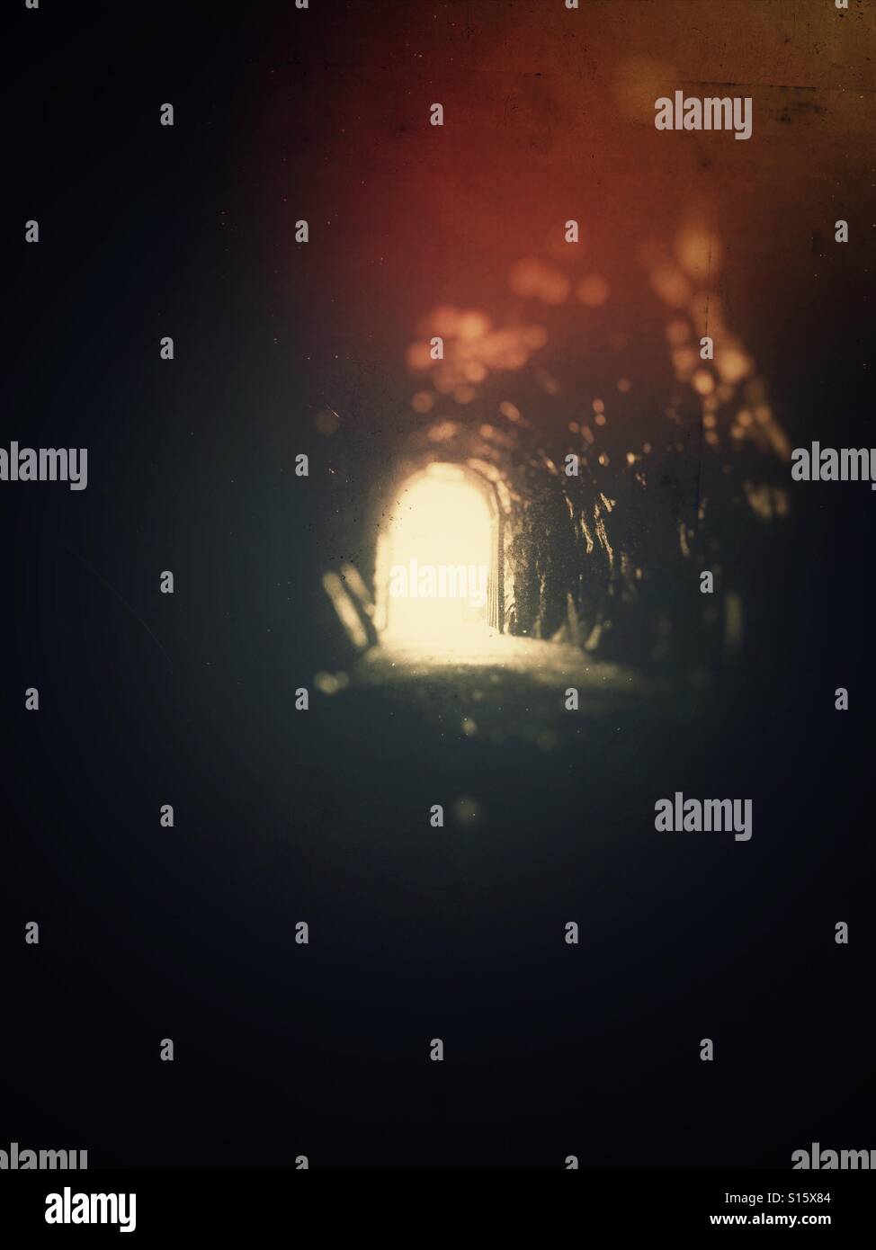 Licht und Reflexionen am Ende eines sehr dunklen Tunnels. - Smartphone-aufgenommenes Stockfoto