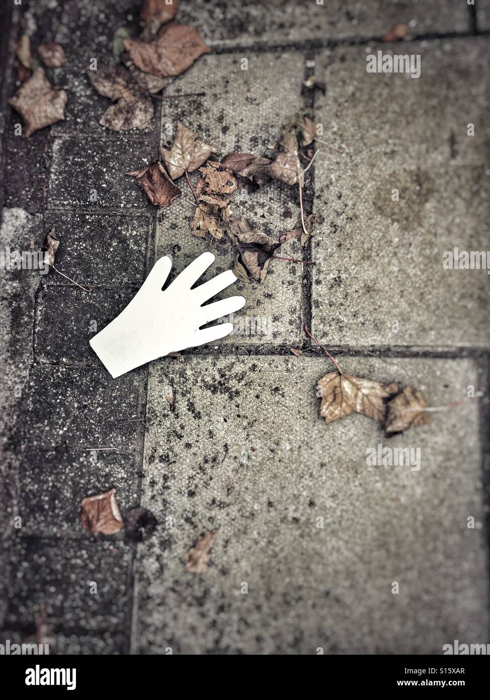 Ausgeschnittenen Papier Hand auf Bürgersteig - Smartphone-aufgenommenes Stockfoto