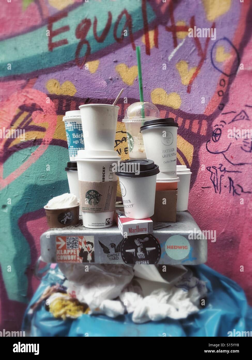 Ein Mülleimer mit Graffiti im Hintergrund voll von leeren Pappbecher Kaffee Stockfoto