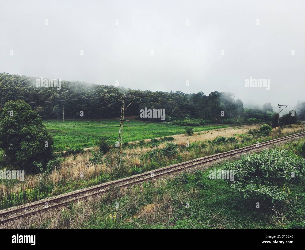 Überrollen die Eisenbahnstrecken in beschaulichen kleinen Städtchen im Nebel Stockfoto