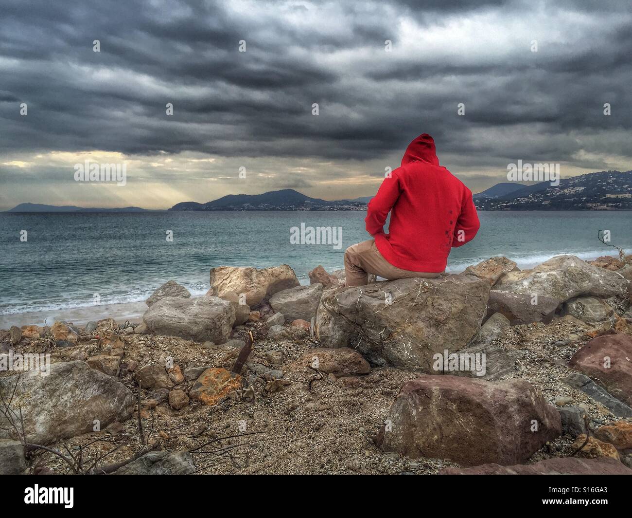 Mann mit Blick auf das Meer, bewölktem Wetter Stockfoto