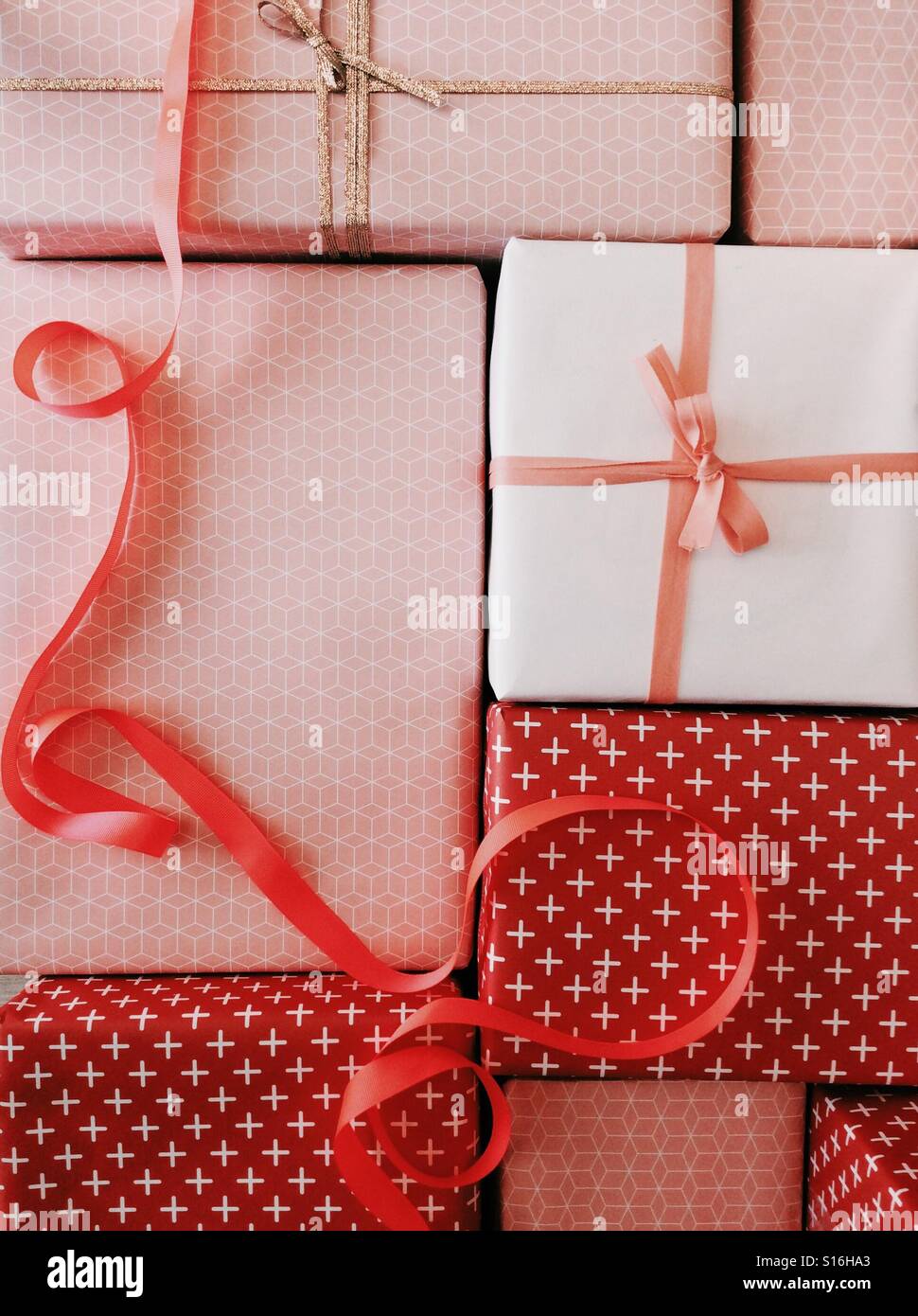 Verpackte Geschenke in rosa und roten Geschenkverpackung mit Schleife Stockfoto
