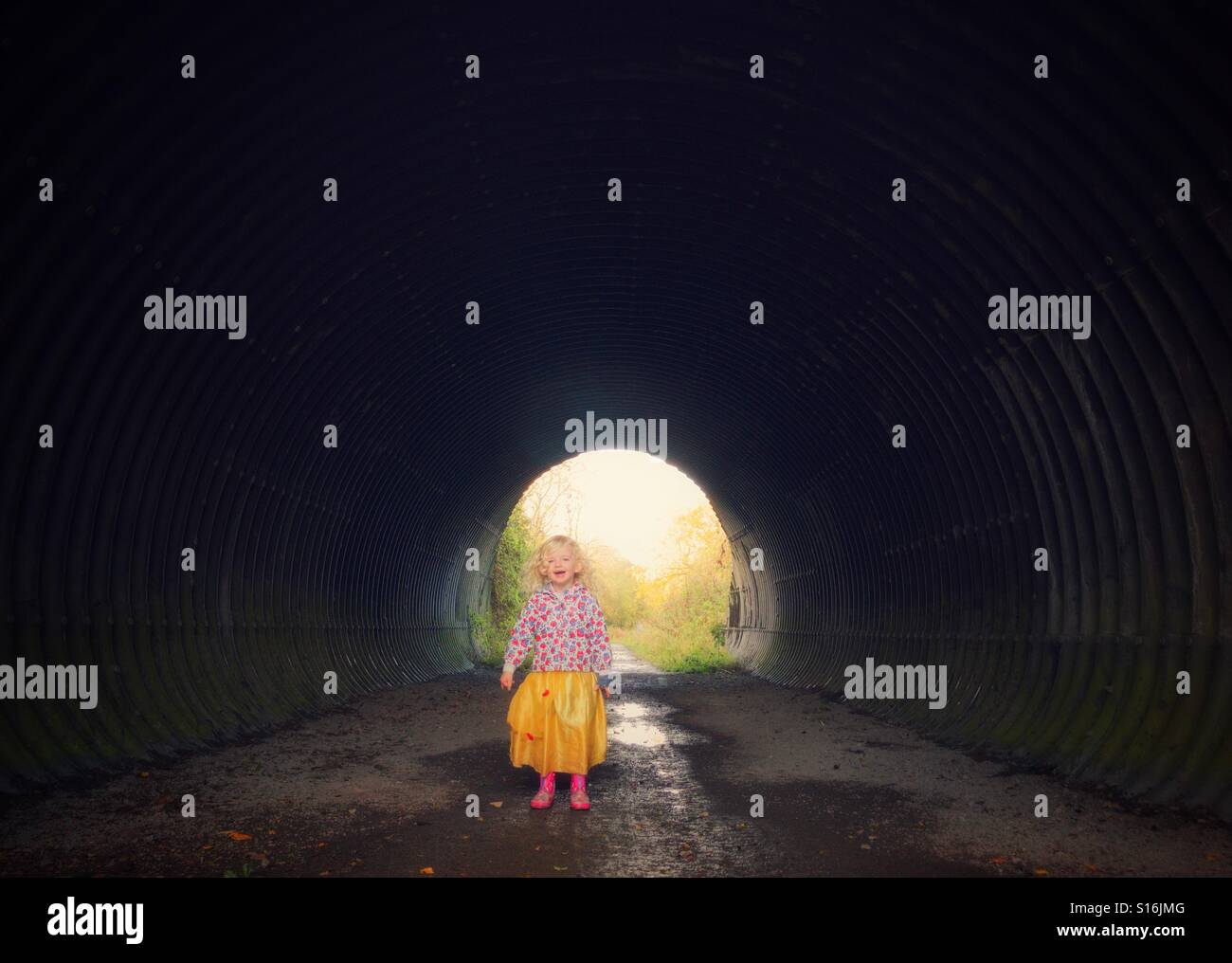 Kleines Kind singt in einem Tunnel genießen die Echos Stockfoto