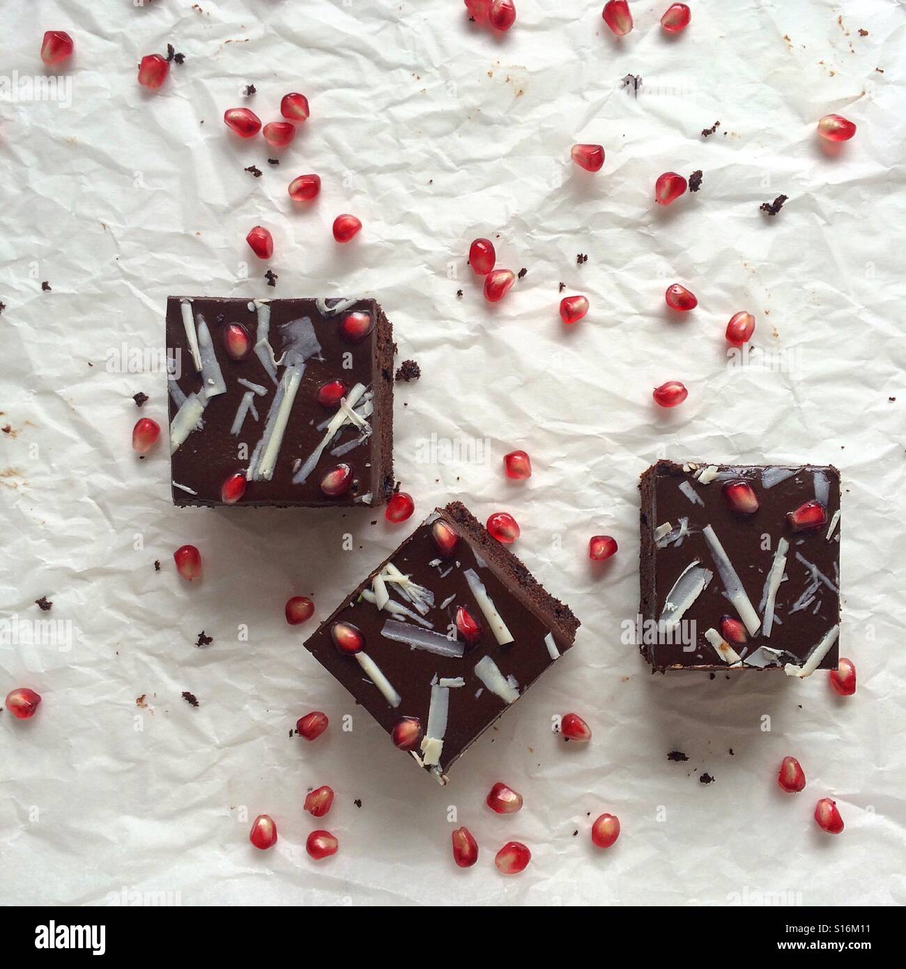 Schokoladenkuchen-Quadrate mit Schokoladen Ganache und Granatapfel Samen. Stockfoto