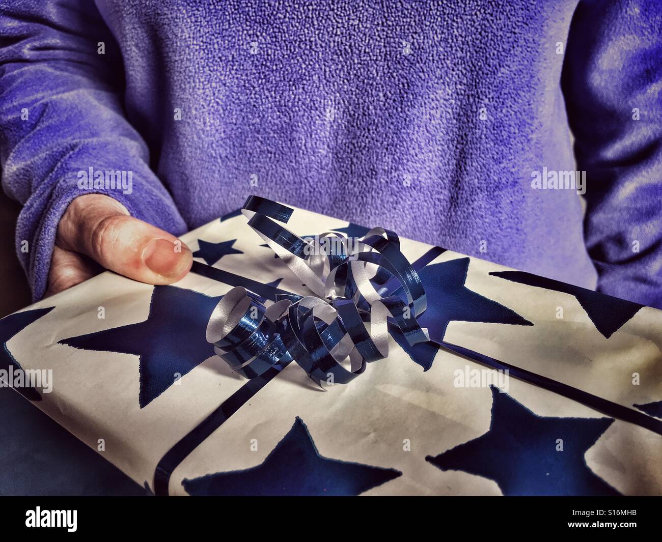 Frau mit einem Geschenk in der Hand, Nahaufnahme - Smartphone-aufgenommenes Stockfoto