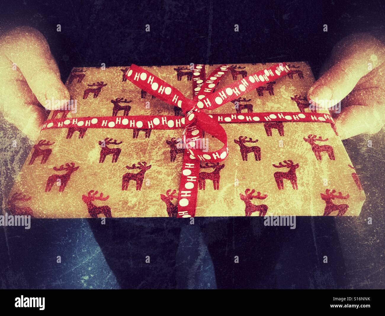 Frau hält ein Weihnachtsgeschenk, Nahaufnahme - Smartphone-aufgenommenes Stockfoto