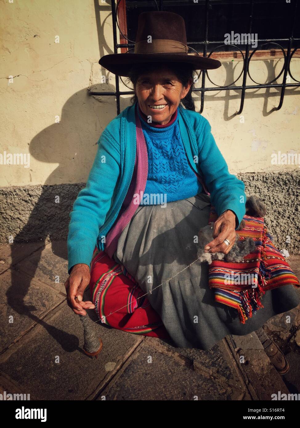 Peruanische Frau Spinnen Garn auf der Straße von Cusco - Smartphone-aufgenommenes Stockfoto