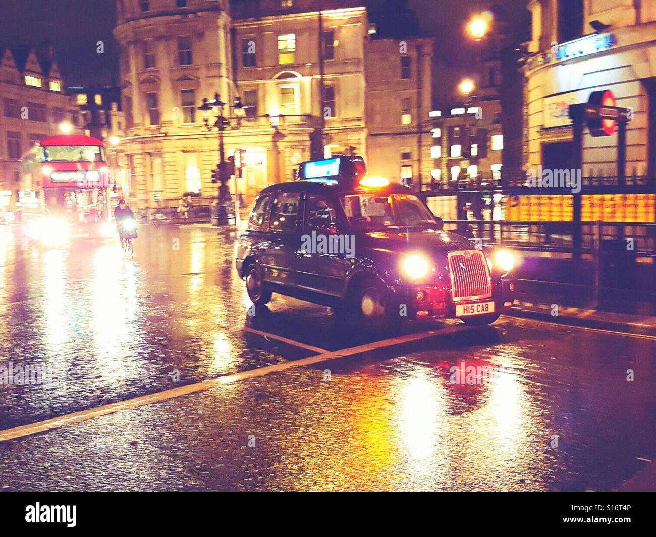 Regnerischen London Straße bei Nacht mit schwarzen Taxi und London-bus Stockfoto