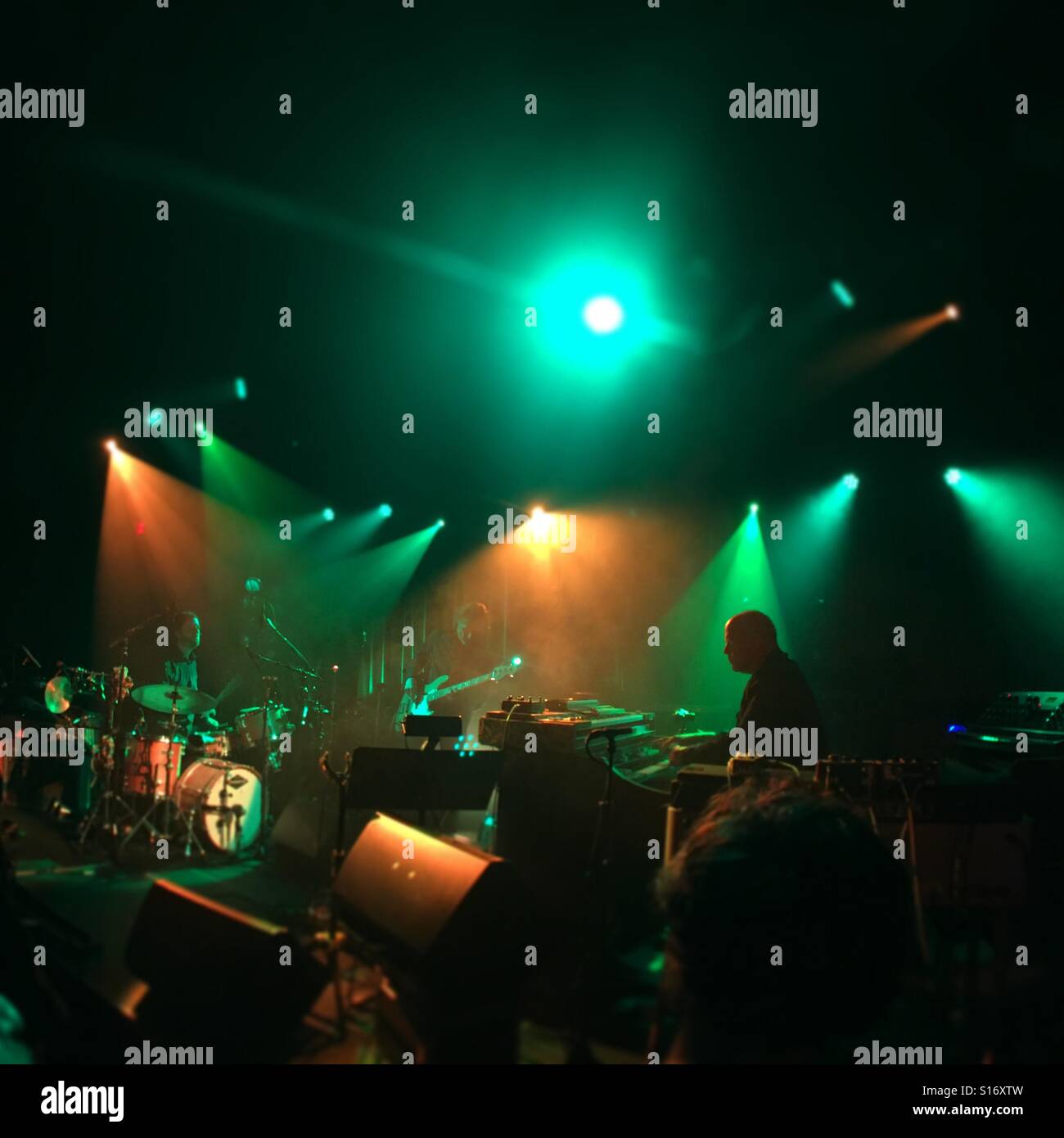 Band auf der Bühne mit Grün und orange Beleuchtung Stockfoto