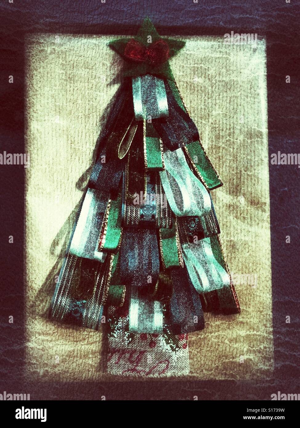 Weihnachtsgeschenk verpackt in braun Normalpapier, dekoriert mit einem Weihnachtsbaum aus Band gemacht. - Smartphone-aufgenommenes Stockfoto