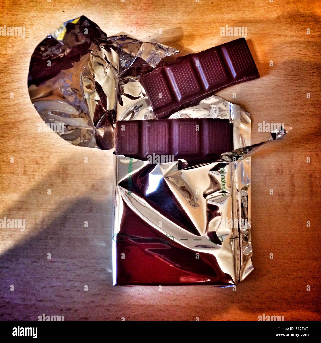 Dunkle Schokolade in zerrissenen Folienverpackung Stockfoto