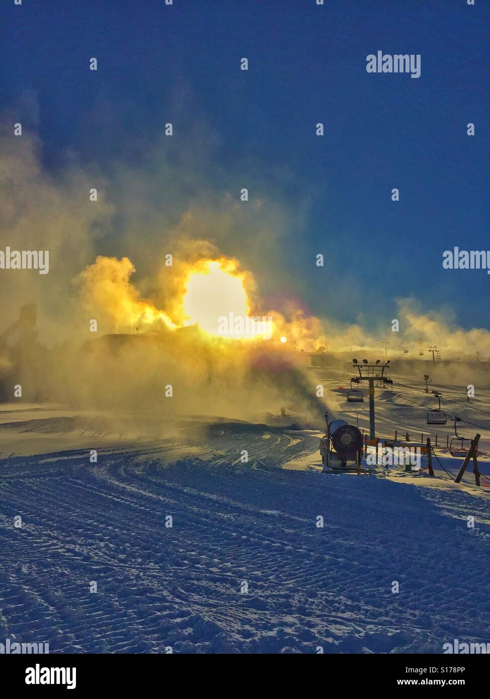 Vorbereitung des Skis hill - Schnee machen und helle Sonne im Hintergrund Stockfoto