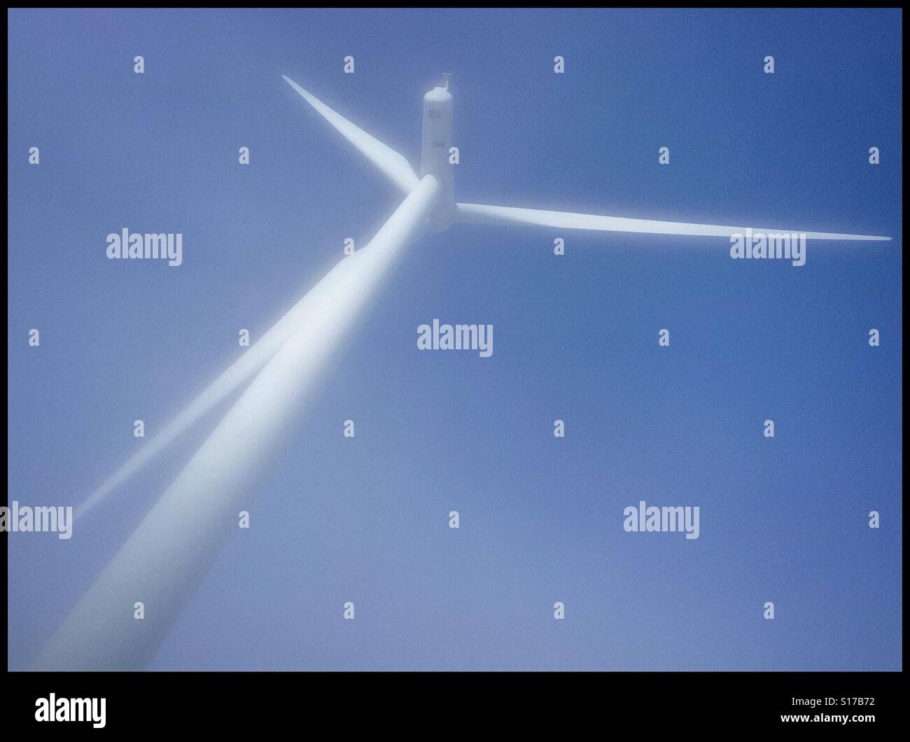 Eine Windkraftanlage ist eingehüllt in den Morgennebel an La Fatarella, Katalonien, Spanien. - Smartphone-aufgenommenes Stockfoto