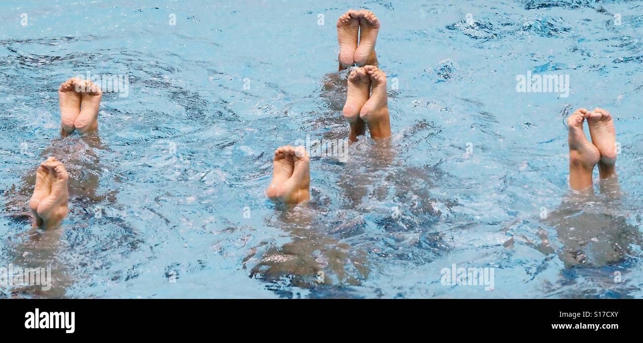 Nur mit die Füßen eines synchronisierte Schwimmen Teams sind aus Wasser gesehen. - Smartphone-aufgenommenes Stockfoto