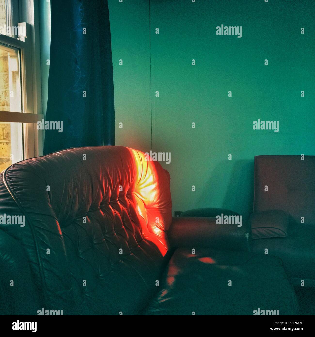 Ein Lichtstrahl trifft ein rotes sofa Stockfoto