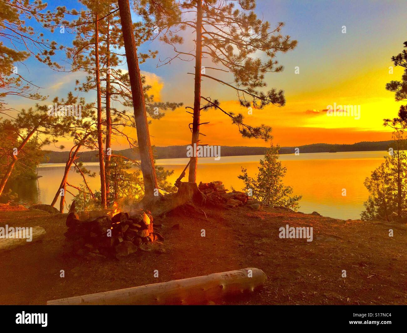 Golden Lake Sonnenlicht Lagerfeuer im Wald Stockfoto
