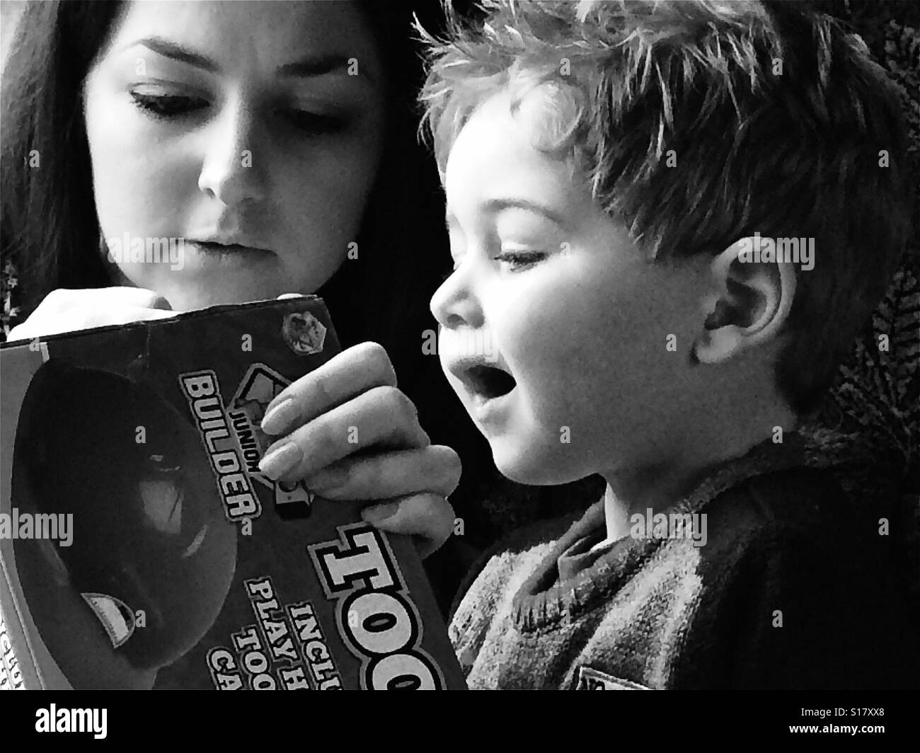 Mutter und Kind suchen bei Toy in schwarz und weiß Stockfoto