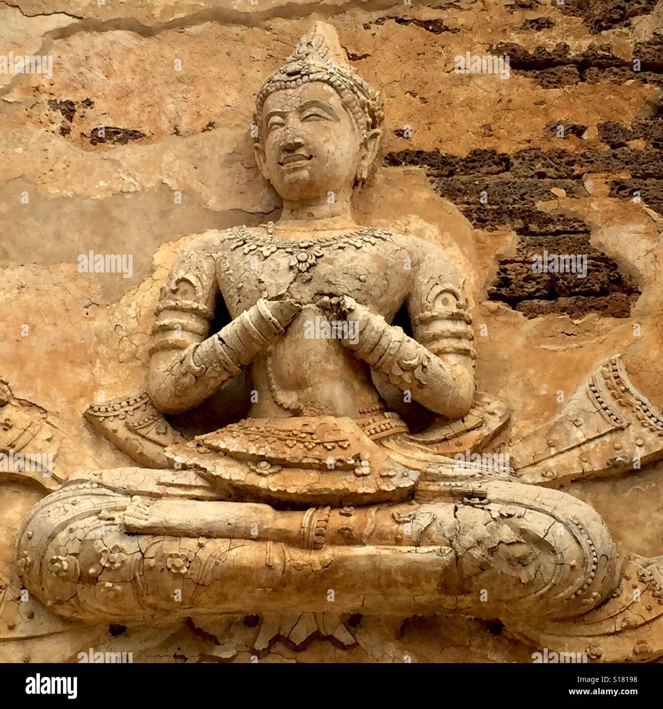 Der Wat Jed Yod ist eine attraktive Lanna Ära Tempelanlage am Stadtrand von Chiang Mai, die einige sehr einzigartige Architektur enthält. Eine gestaltete Gottheit auf die Tempelmauer, Thailand. Stockfoto