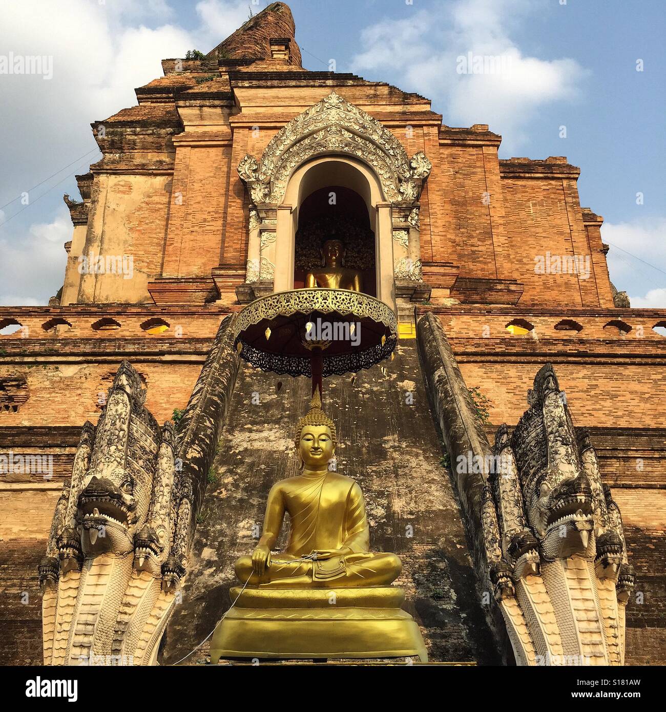 Buddha-Statue zwischen ein paar Schlangen im Wat Chedi Luang, Chiang Mai, Thailand Stockfoto