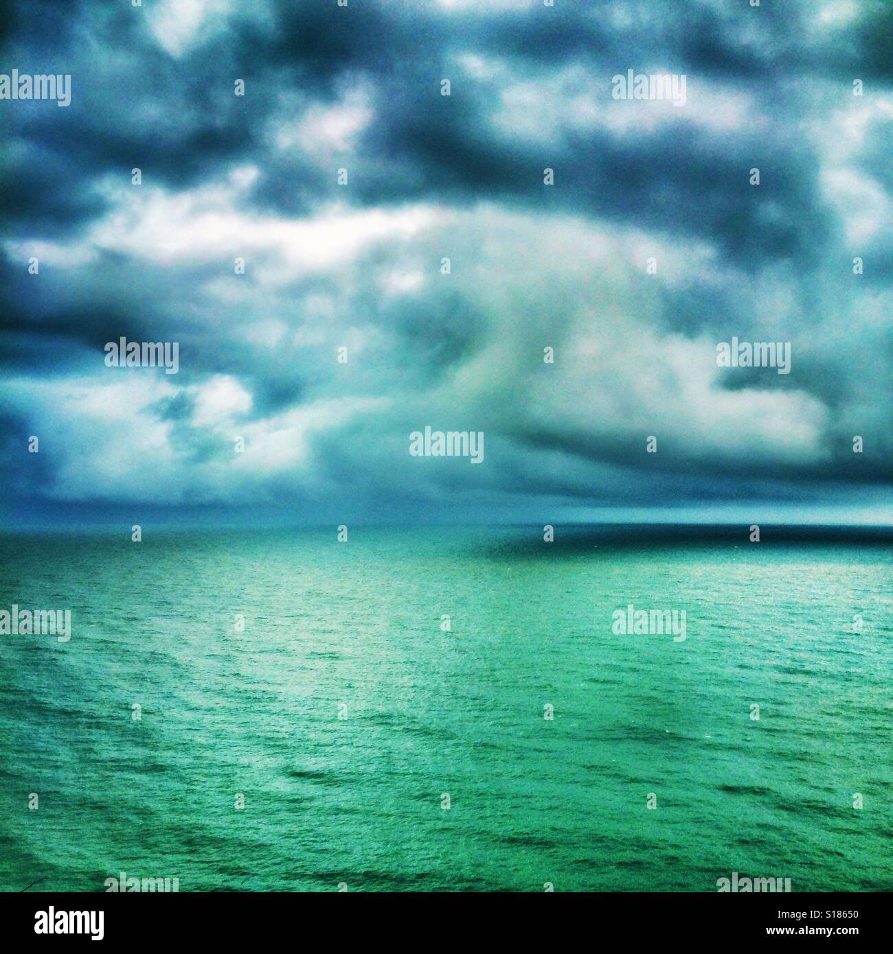 Gewitterwolken über einen türkisfarbenen Meer Stockfoto