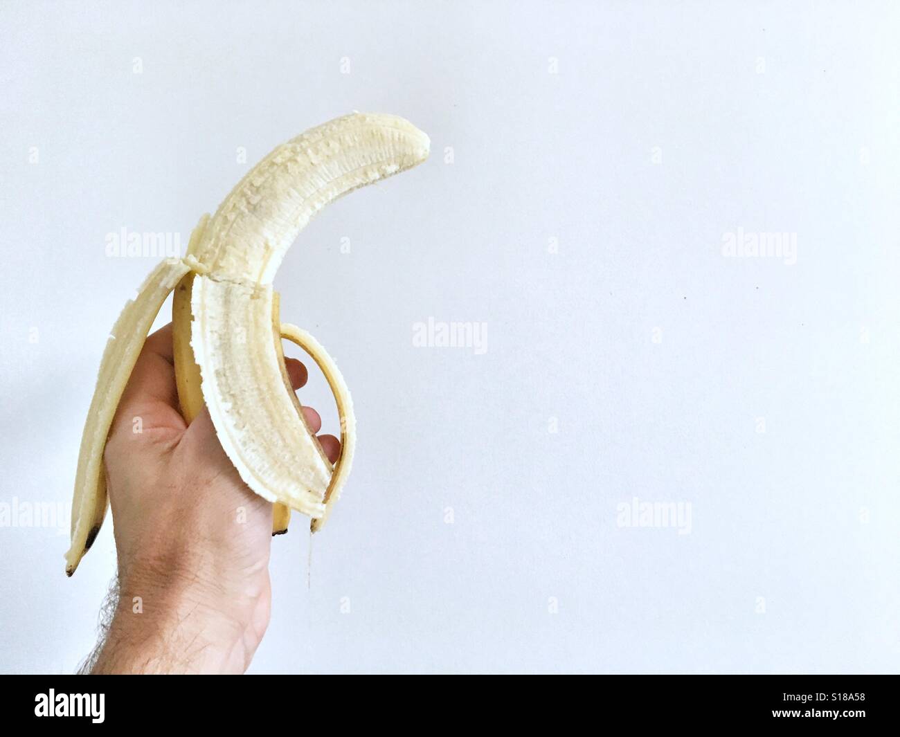 Mannes Hand hält eine Banane. - Smartphone-aufgenommenes Stockfoto