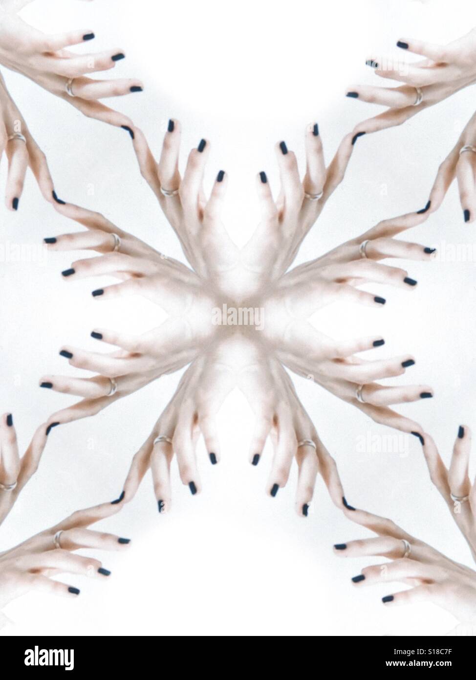Eine abstrakte Konzeptbild eines sich wiederholenden Designs. Erstellt von weiblichen Finger vor einem weißen Hintergrund Stockfoto