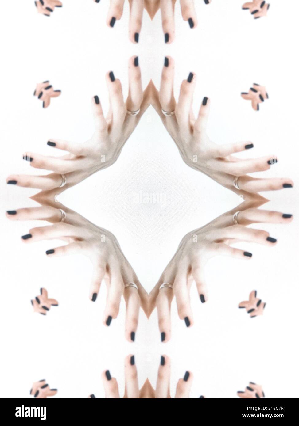 Eine abstrakte Konzeptbild eines sich wiederholenden Designs. Erstellt von weiblichen Finger vor einem weißen Hintergrund Stockfoto