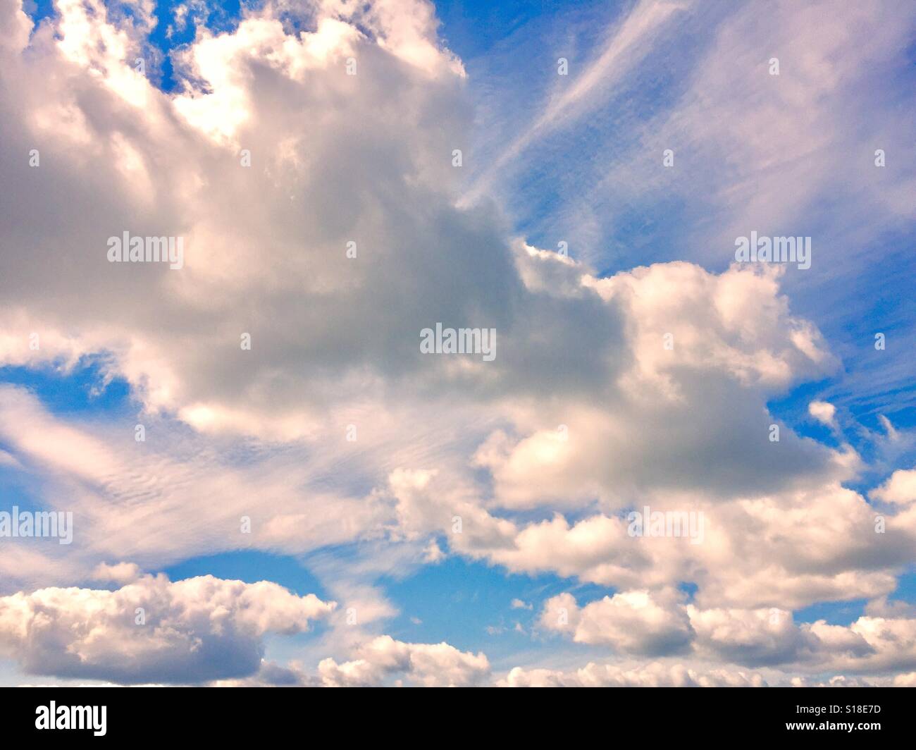 Geschwollene weiße Wolken Sonne und blauer Himmel Stockfoto