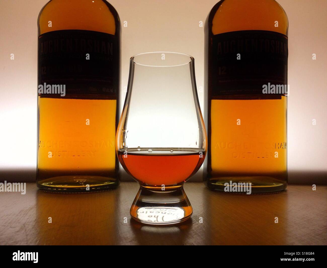 Ein Glas single Malt Scotch Whisky vor zwei Flaschen. Stockfoto