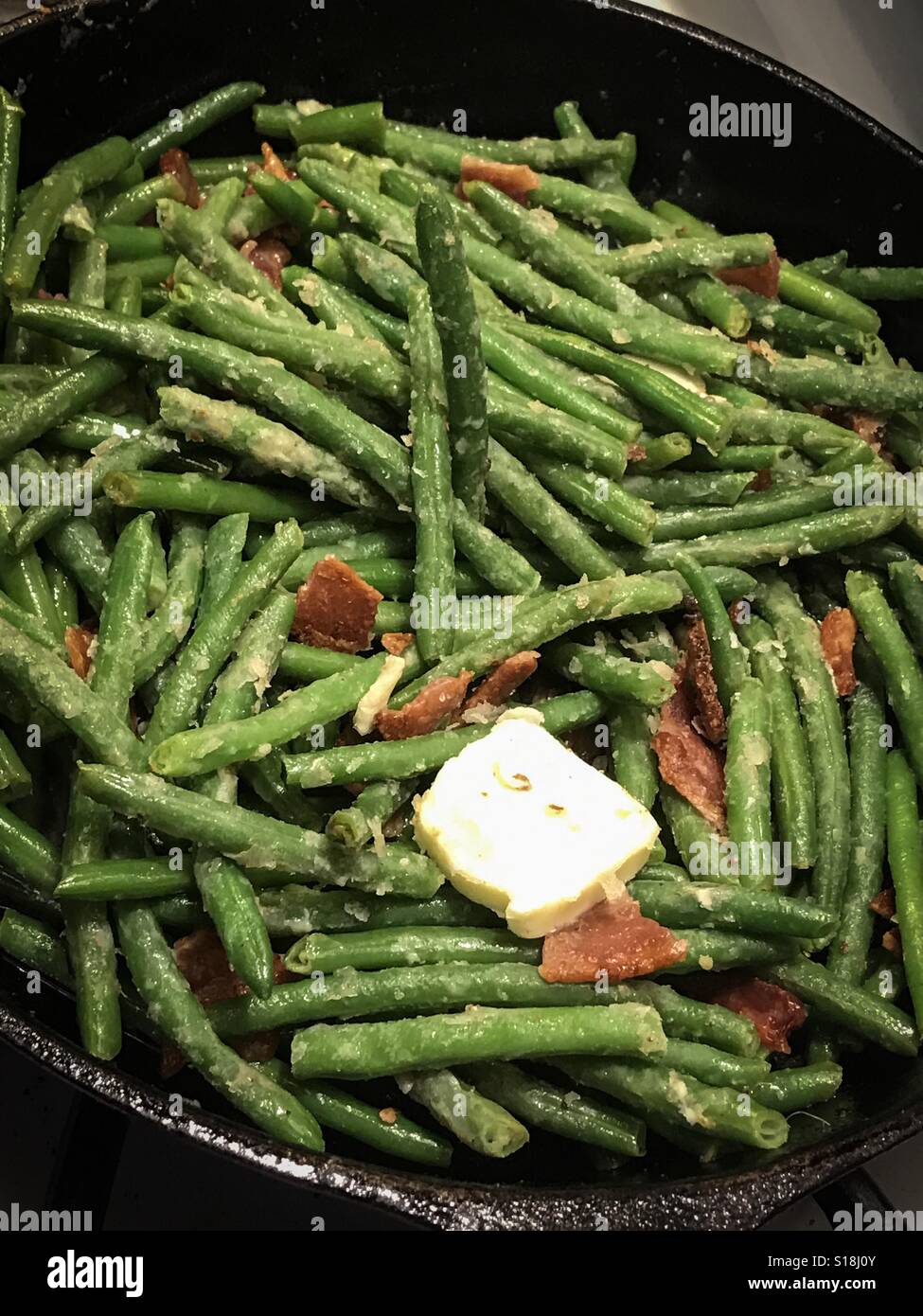 Grüne Bohnen, Speck und Butter in einer Pfanne gekocht wird. Stockfoto