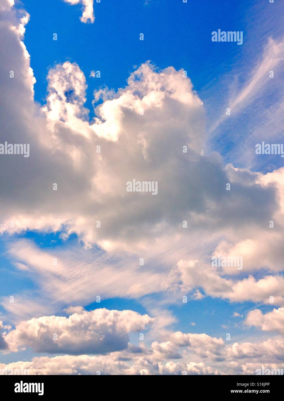 Geschwollene weiße Wolken, blauer Himmel und Sonne Portrait Stockfoto