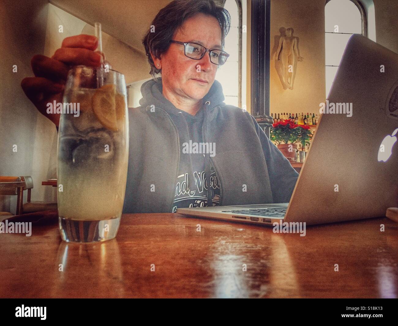 Frau in einem Restaurant arbeiten auf ihrem iMac trinken frische lemonafe Stockfoto