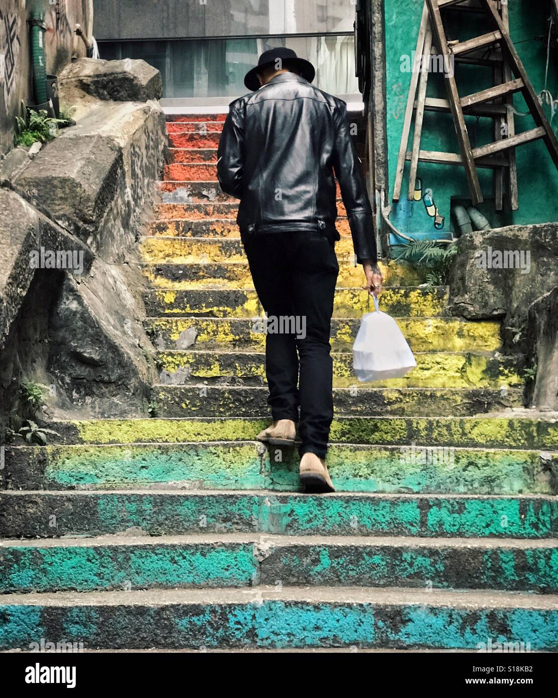 Ein Kerl Treppensteigen ein Mittagessen Tragetasche Stockfoto