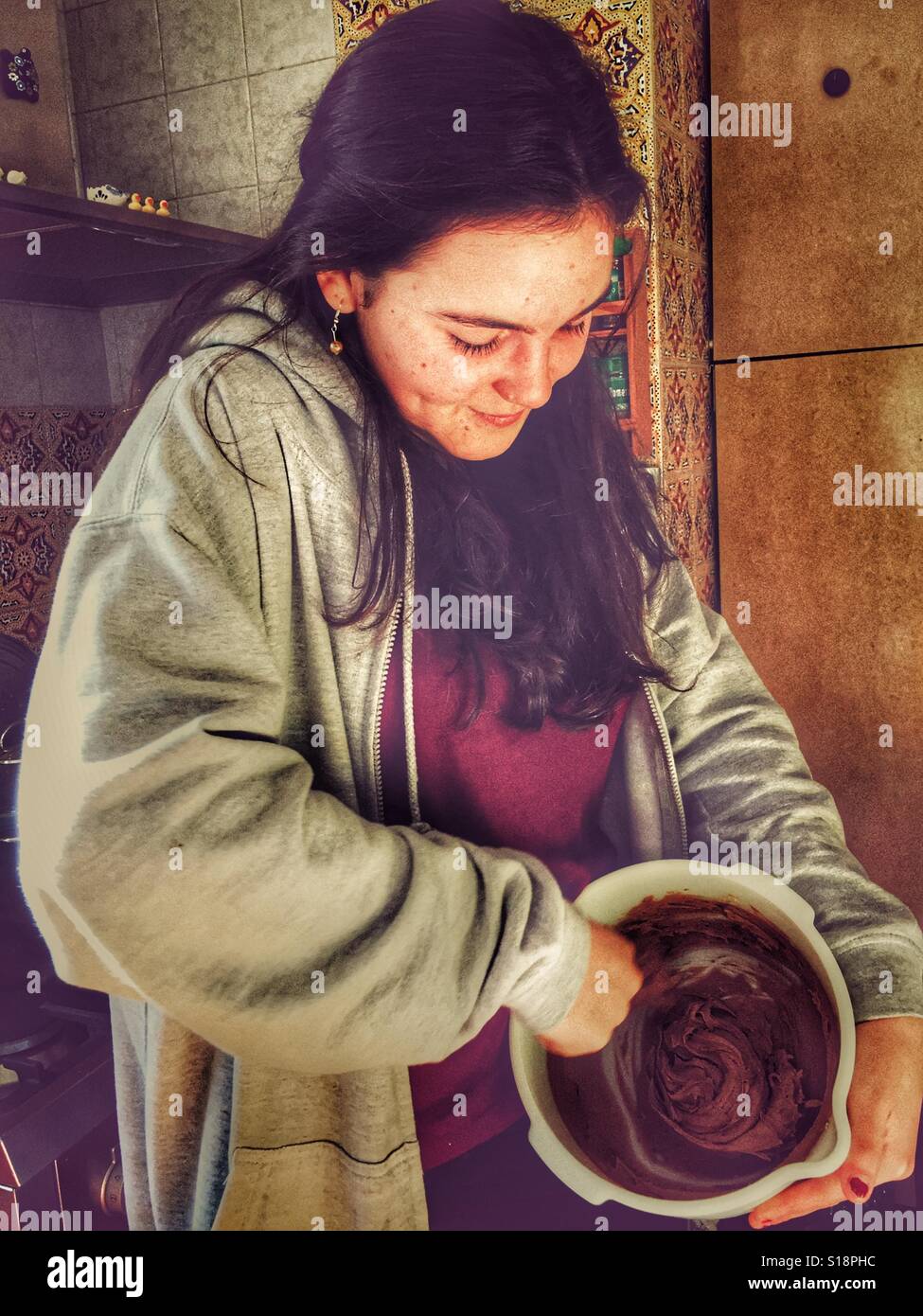 Teenager mischen Sahnehäubchen auf Kuchen gehen Stockfoto