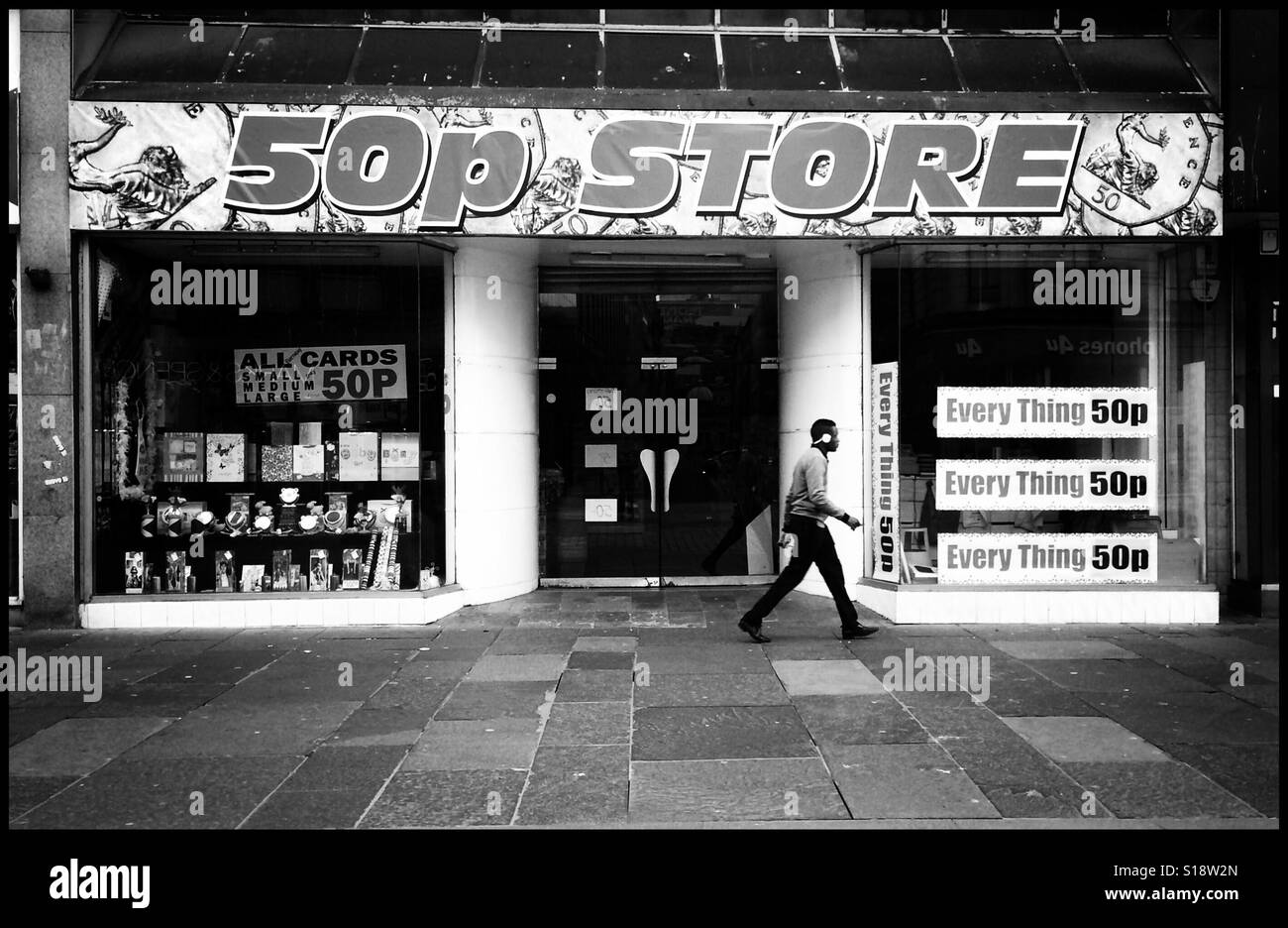 Ein Mann geht vorbei an einem 50p-Store in Glasgow, Schottland, dass Angebote Produkte Rabatt. Stockfoto