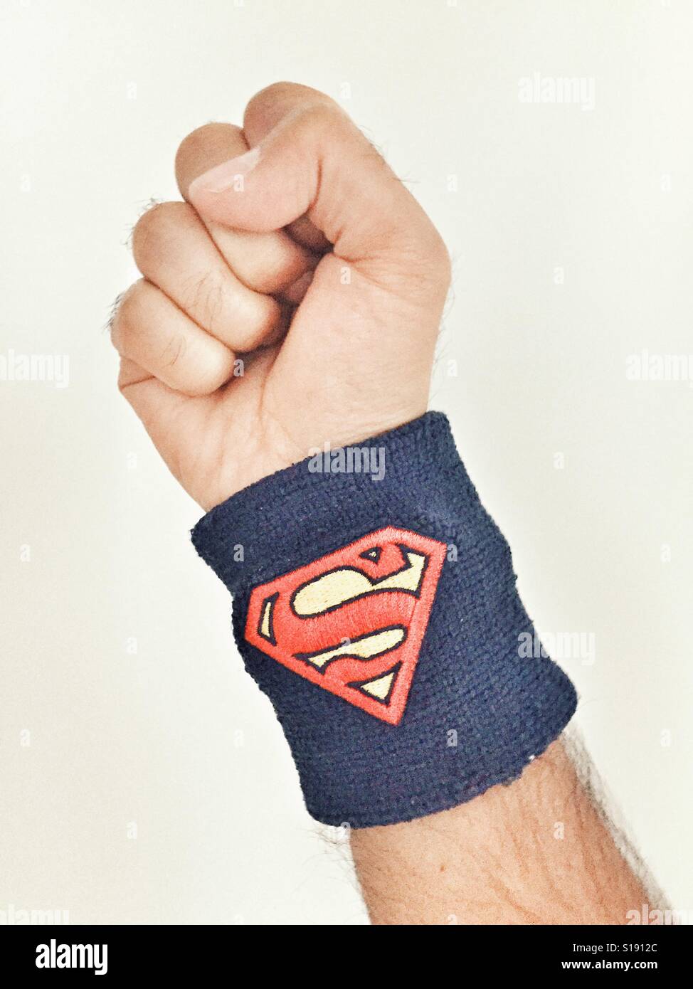 Geschlossene Hand tragen Superman-Armband - Smartphone-aufgenommenes Stockfoto