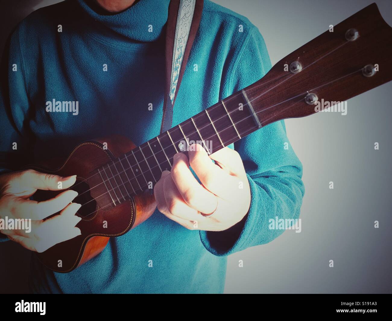 Frau spielt eine Ukulele - Smartphone-aufgenommenes Stockfoto