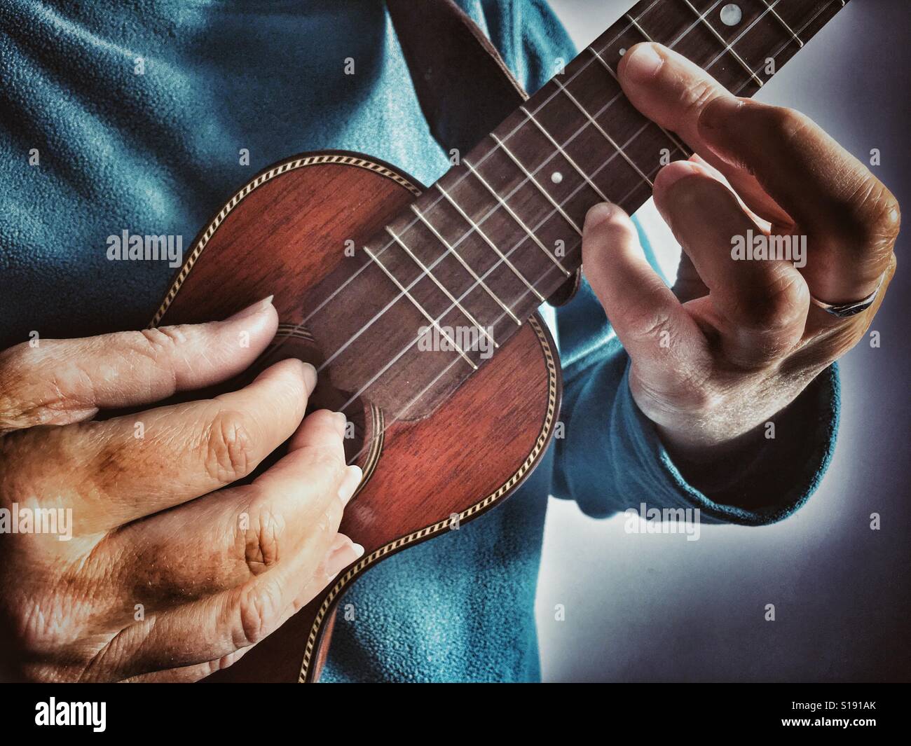 Spielen eine Ukulele, Fingerstyle - Smartphone-aufgenommenes Stockfoto