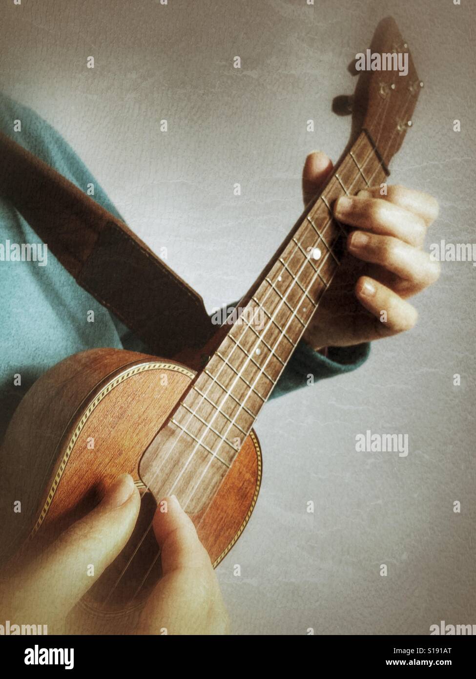 Spielen eine Ukulele, Fingerstyle - Smartphone-aufgenommenes Stockfoto
