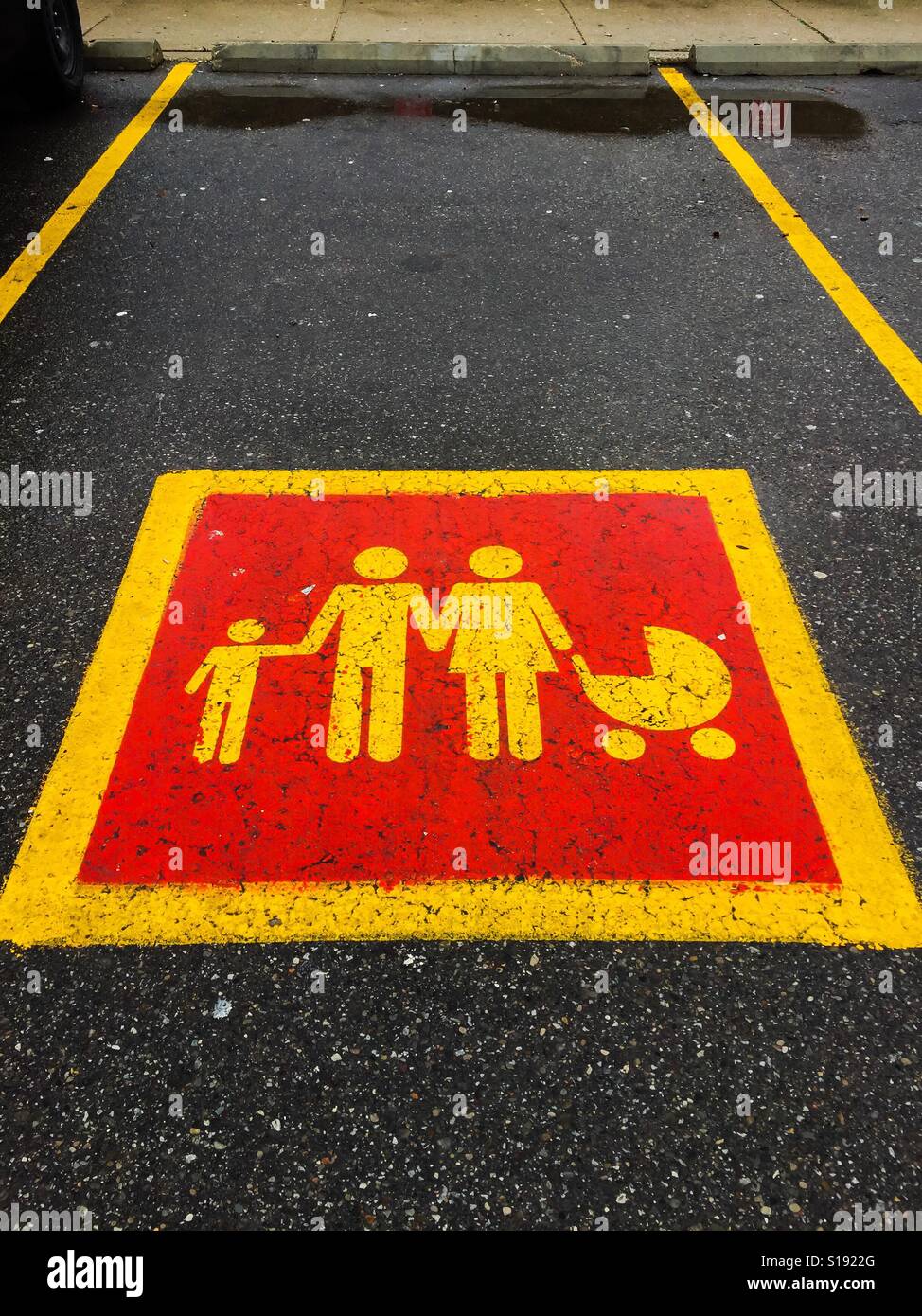 Parkplatz für Familien vor einem Einkaufszentrum. Piktogramm. Bild. Auf Asphalt gemalt. Gelb. Orange. Platz für Text Stockfoto