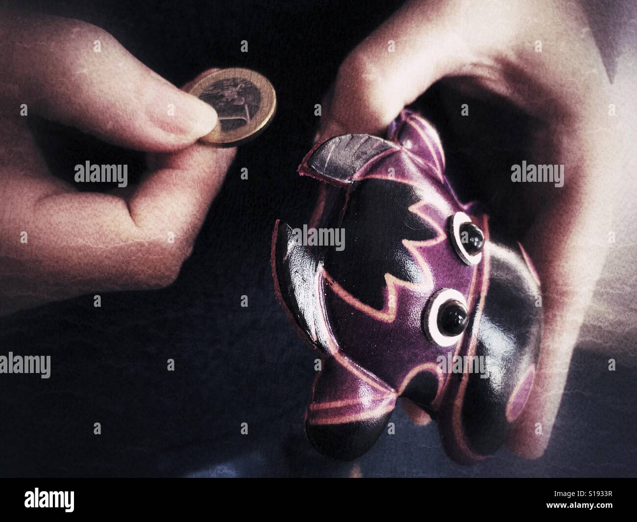 Nehmen eine Münze aus einem lila Kuh Lederbeutel. - Smartphone-aufgenommenes Stockfoto