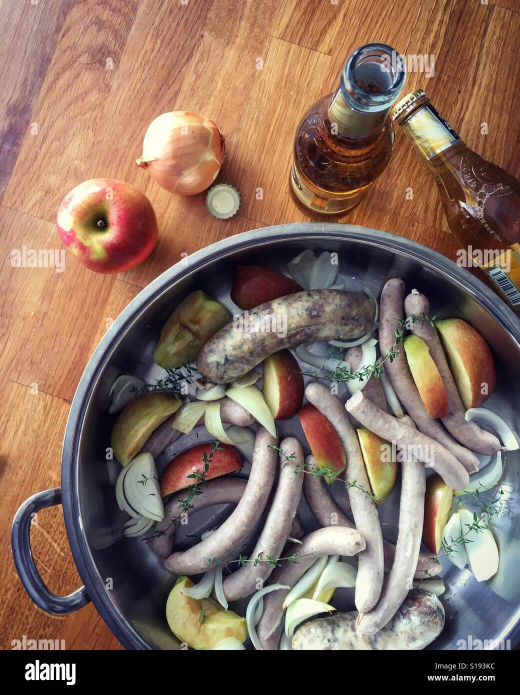 Würstchen-Backen mit Apfel und Apfelwein Stockfoto