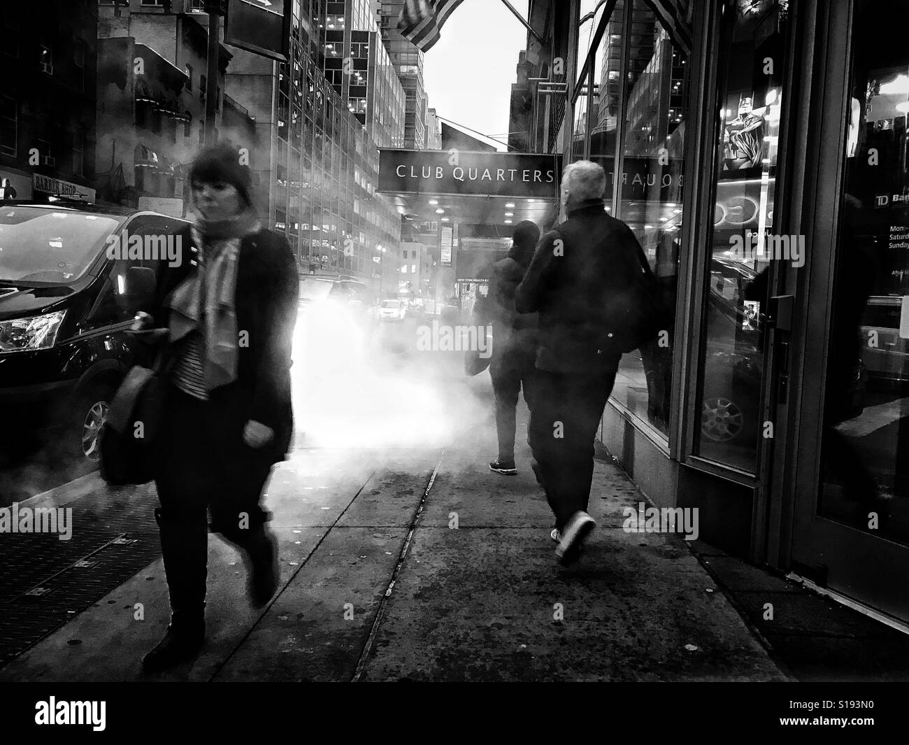 Fußgänger gehen durch Dampf steigt aus einem Schlot an der Manhattan Street. Stockfoto