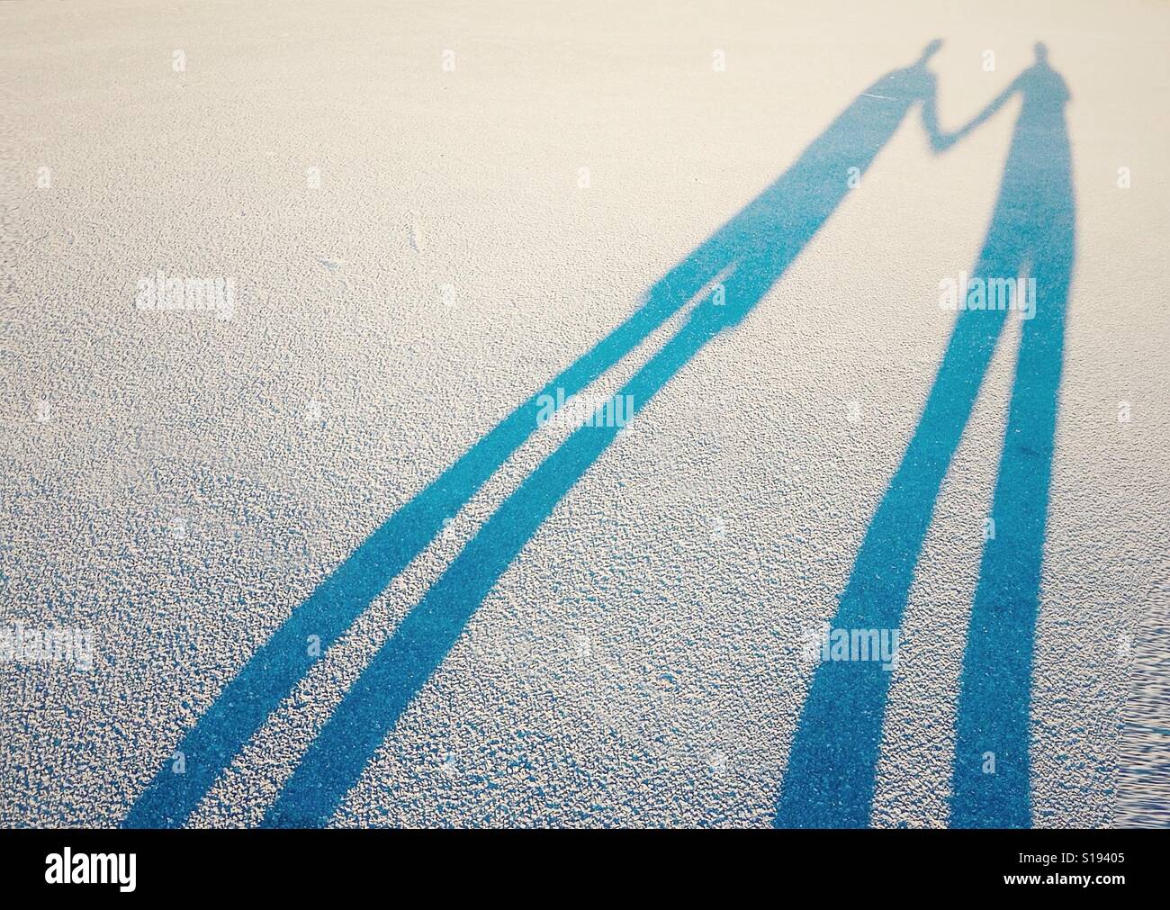 Lange Schatten von ein paar Liebhaber Hand in Hand Stockfoto