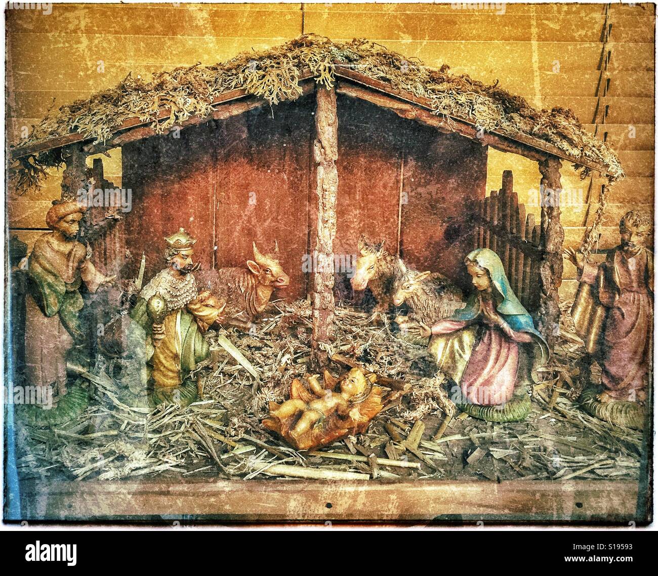 Ein Grunge-Effekt Bild eines Modells für die Weihnachtskrippe. Das Jesuskind ist in seinem Bettchen, umgeben von Maria, Joseph, Kühe & The Tree weisen mit Geschenken. Bildnachweis - © COLIN HOSKINS. - Smartphone-aufgenommenes Stockfoto