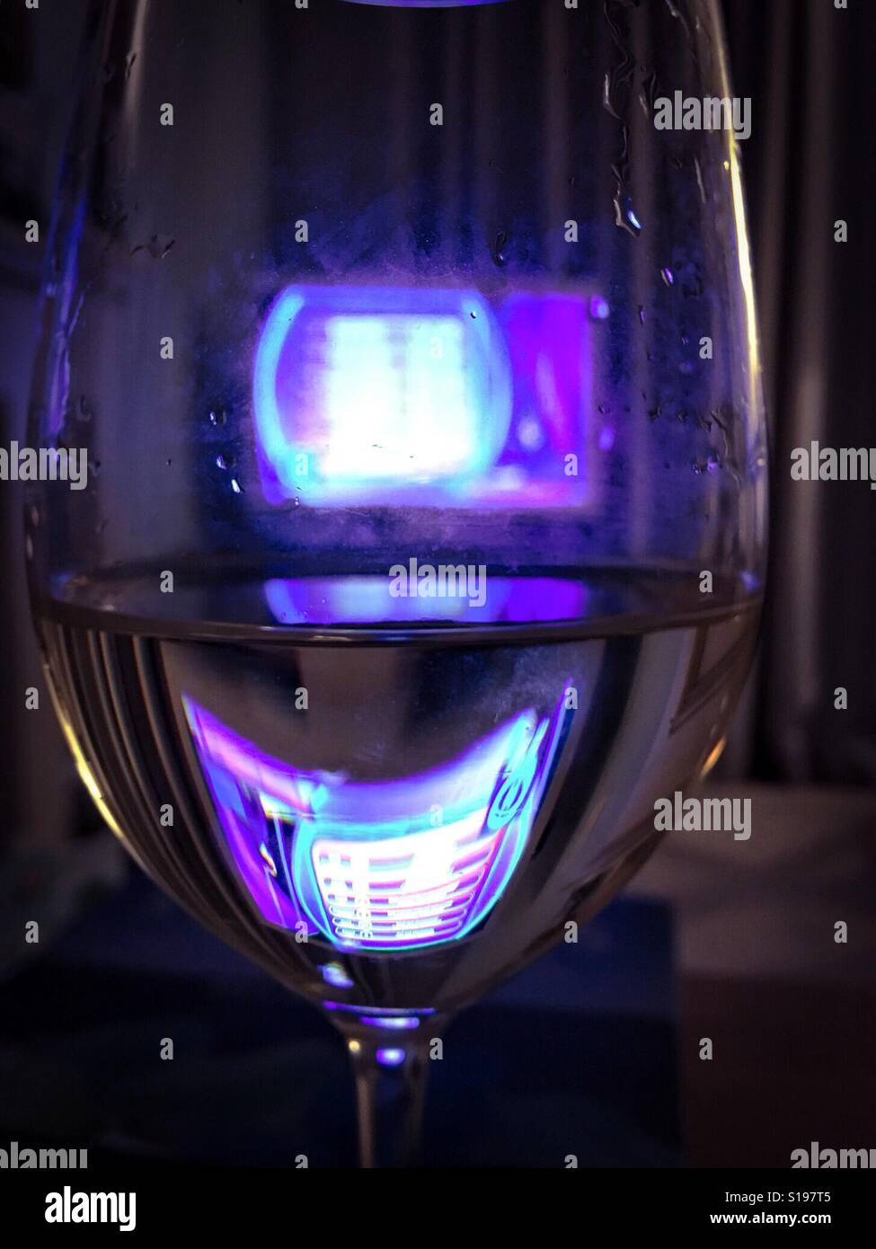 TV durch ein Glas Wein Stockfoto