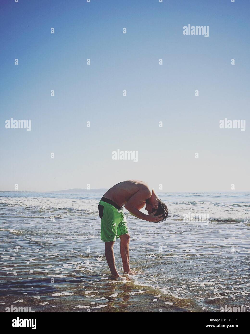 Mann, die Haare im Ozean spülen Stockfoto
