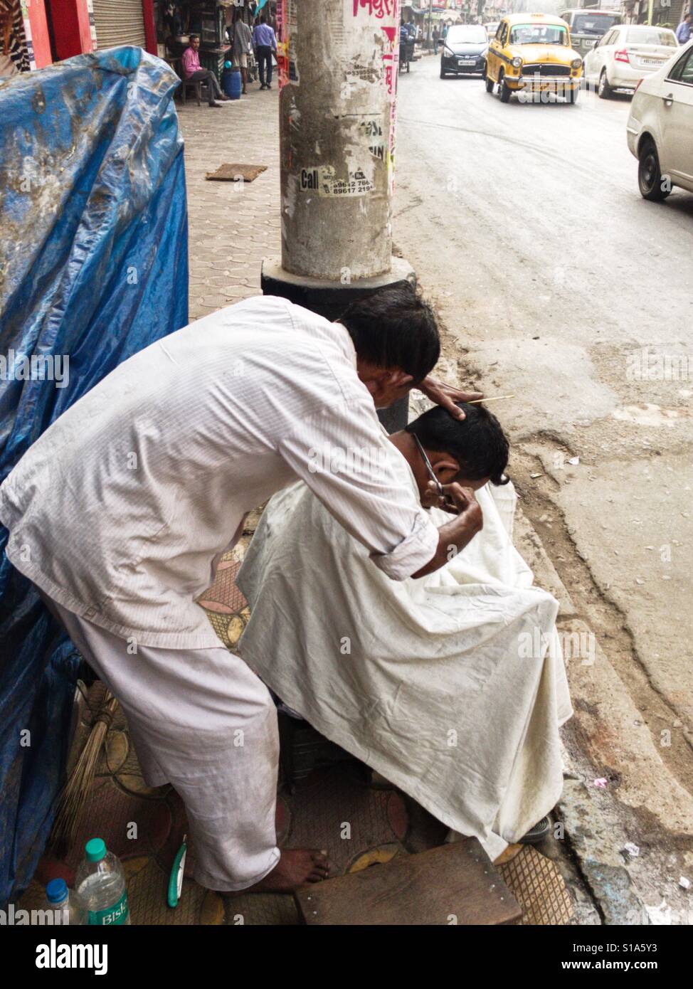Haarschnitt am Straßenrand, Kolkata, Indien - Smartphone-aufgenommenes Stockfoto