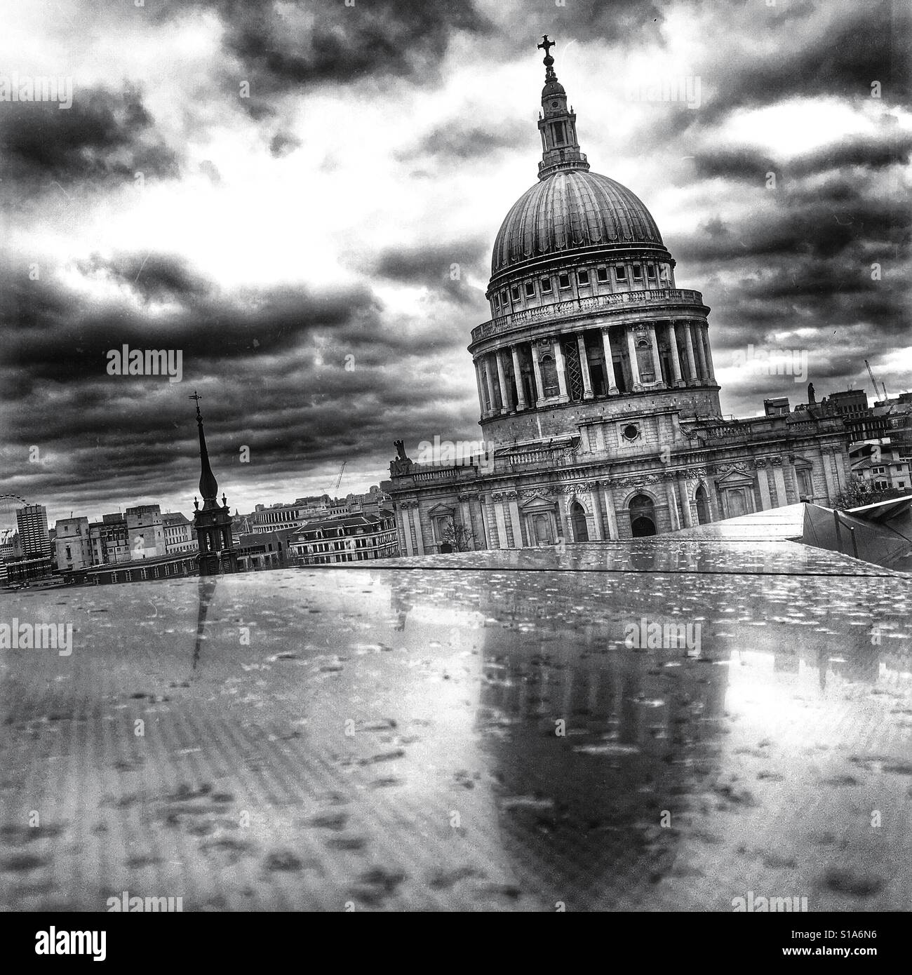 Schwarz / weiß Foto von Saint-Paul Kathedrale spiegelt sich auf einen Regen durchnässt Dach unter einem dramatischen Himmel in London, England, UK. Stockfoto