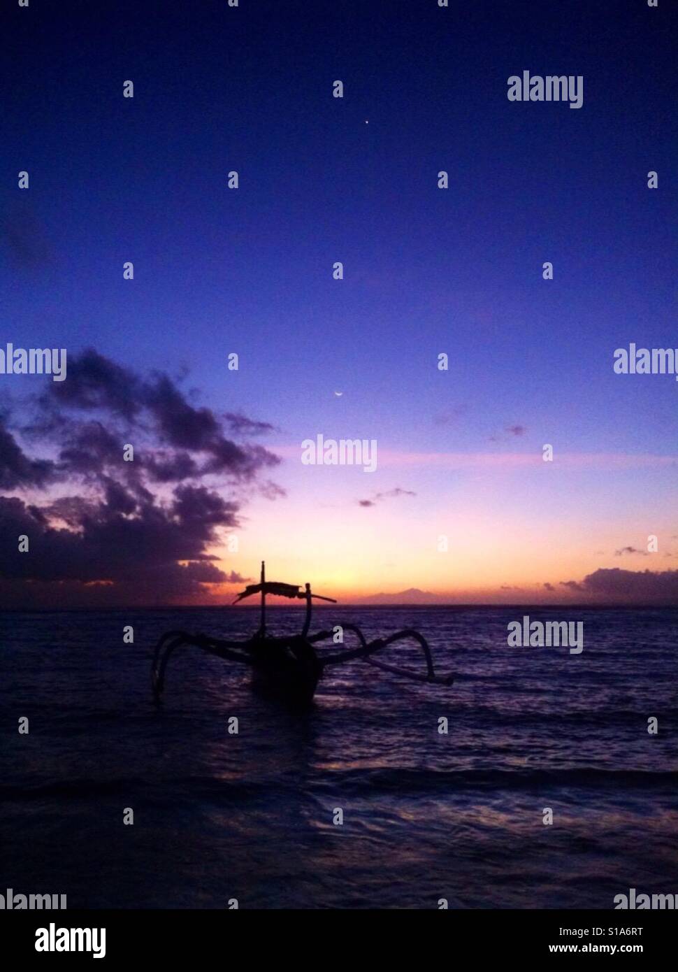 Silhouette von einem Fischerboot im Ozean beim Sonnenuntergang Stockfoto